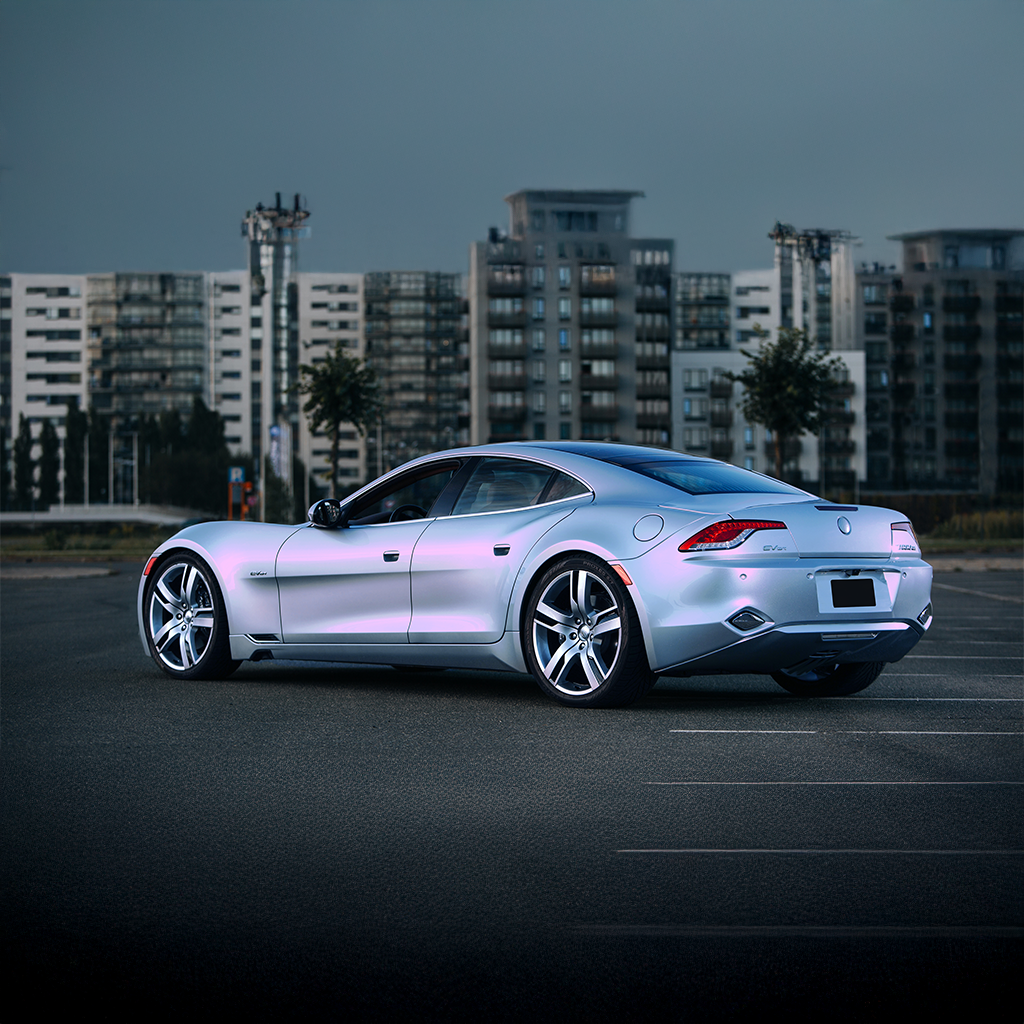 Silver sports car in a parking lot with buildings in the background