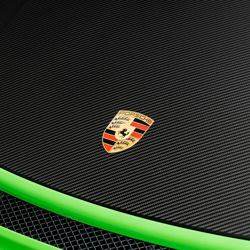 Porsche logo on a black textured surface with green trim