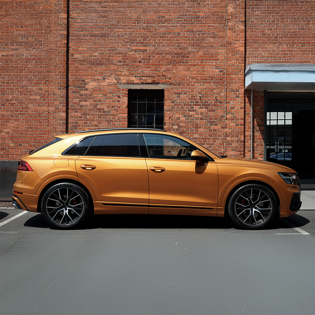 Orange SUV parked in front of a brick building