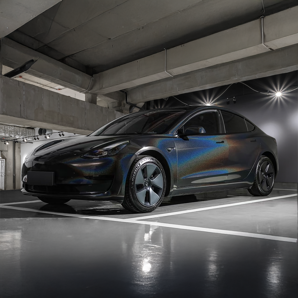 Black electric car parked in a dimly lit underground parking garage.
