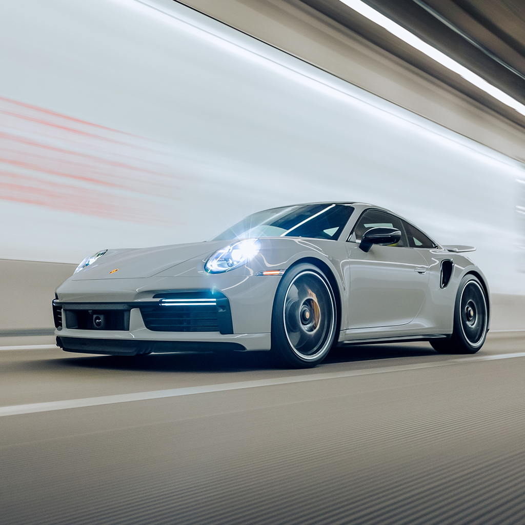 Gray Porsche sports car driving on a blurred road