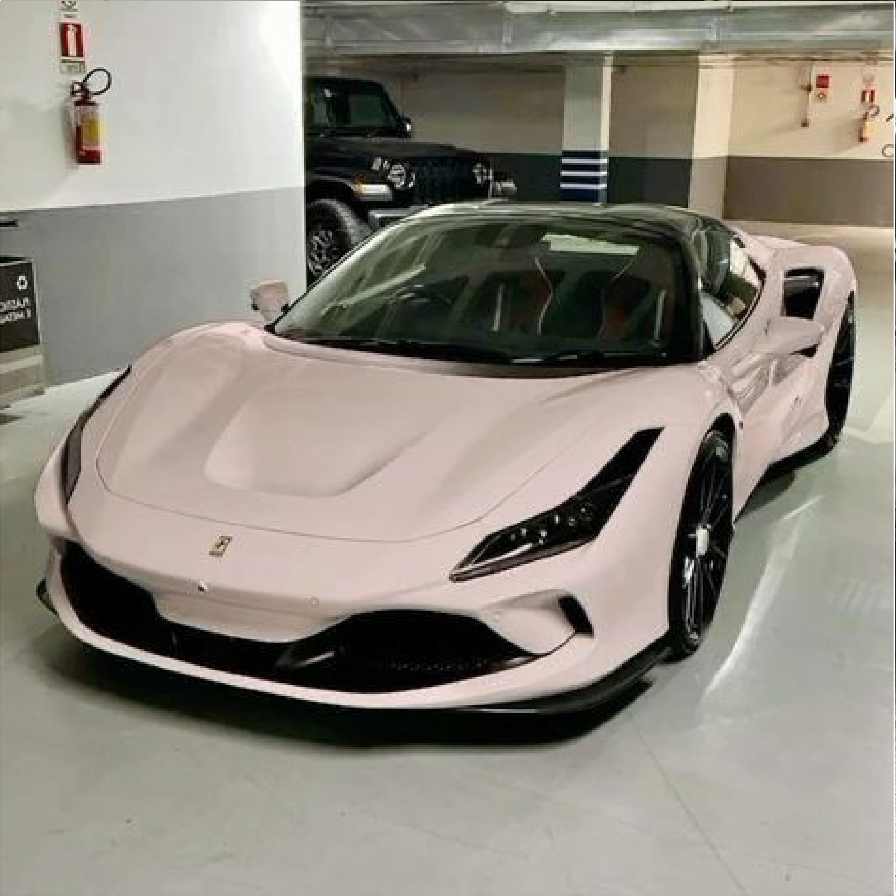 Perfect peach sports car in a garage with another vehicle in the background
