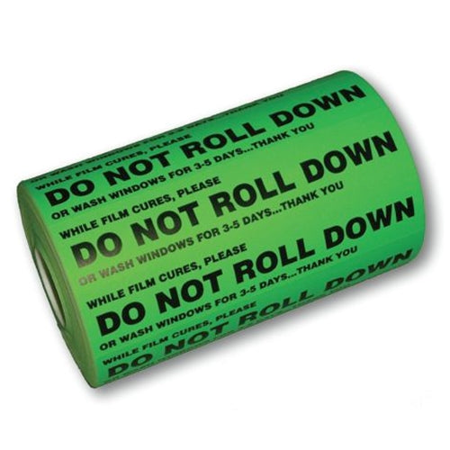 A roll of green 'DO NOT ROLL DOWN' decals with text instructions for window tinting.