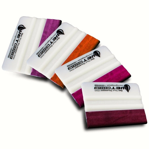 A collection of colorful wet edge squeegees laid out in a fan shape, with white edges and colored bodies.