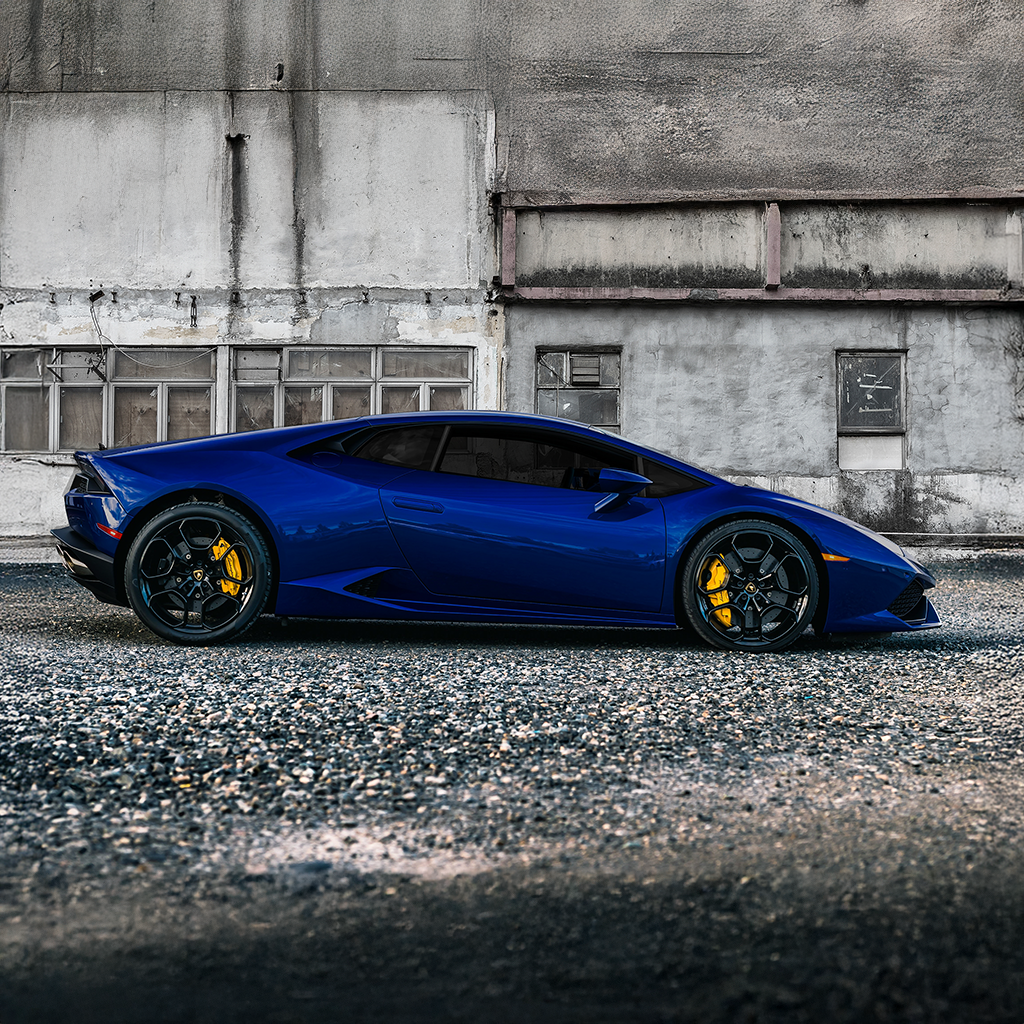 Blue sports car parked in front of an industrial building