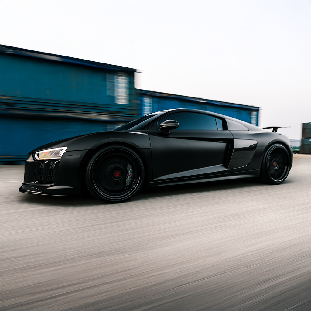 Black sports car driving on a track with a blurred background