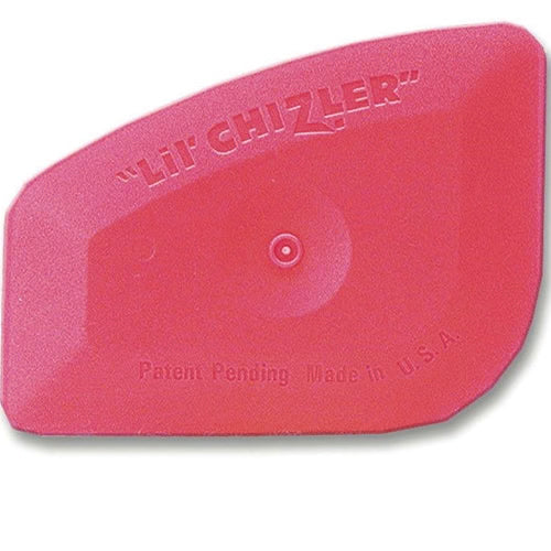 A pink tool known as 'Lil' Chizler' for window tinting, with embossed text on its surface.