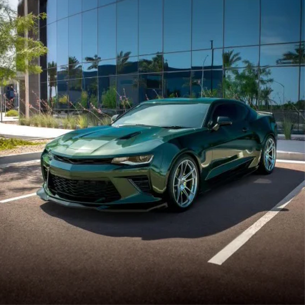Gloss British Racing Green Metallic Vinyl Car Wrap with deep green color and high-gloss metallic finish, shown partially unrolled for vehicle application.  