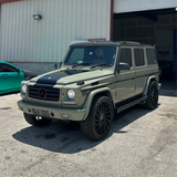 Green Mercedes-Benz G-Class SUV parked in front of a building