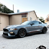Gray Mustang sports car parked in front of a building