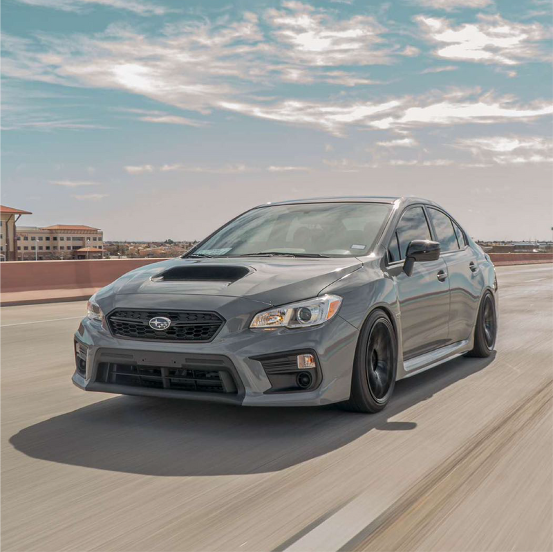 Gray Subaru car on a road with a clear sky