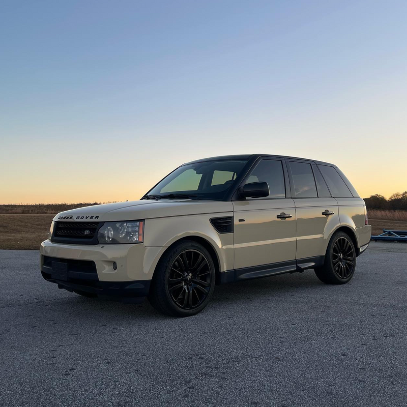 Land Rover Range Rover parked on a paved surface with a sunset sky.