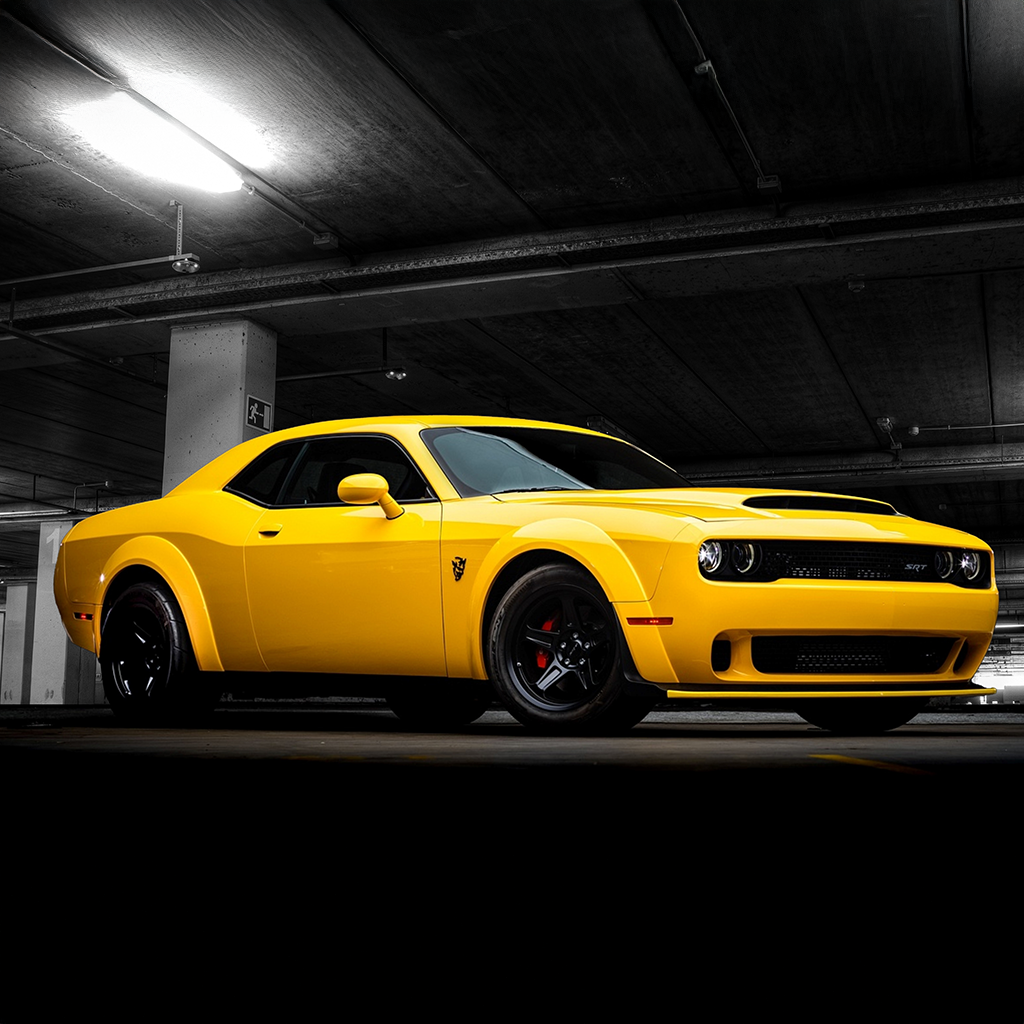 Yellow muscle car in a dimly lit parking garage