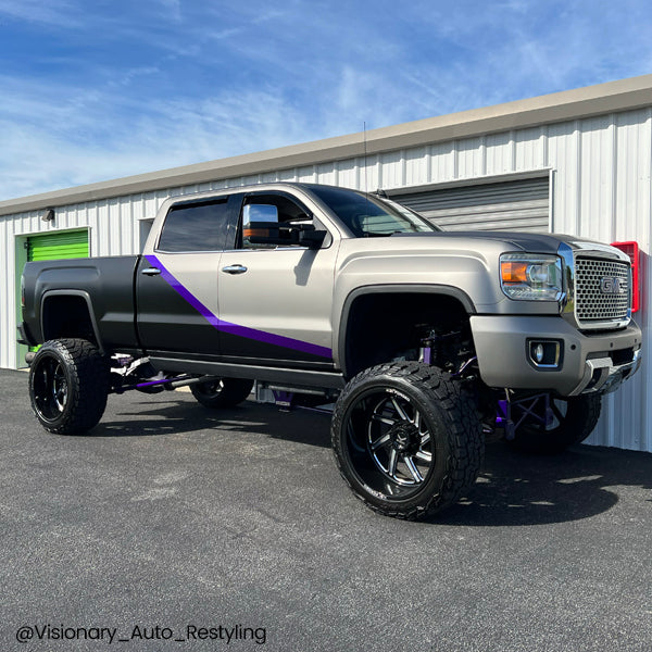 Lifted GMC Sierra pickup truck with two-tone satin black and silver car wrap featuring purple accents.
