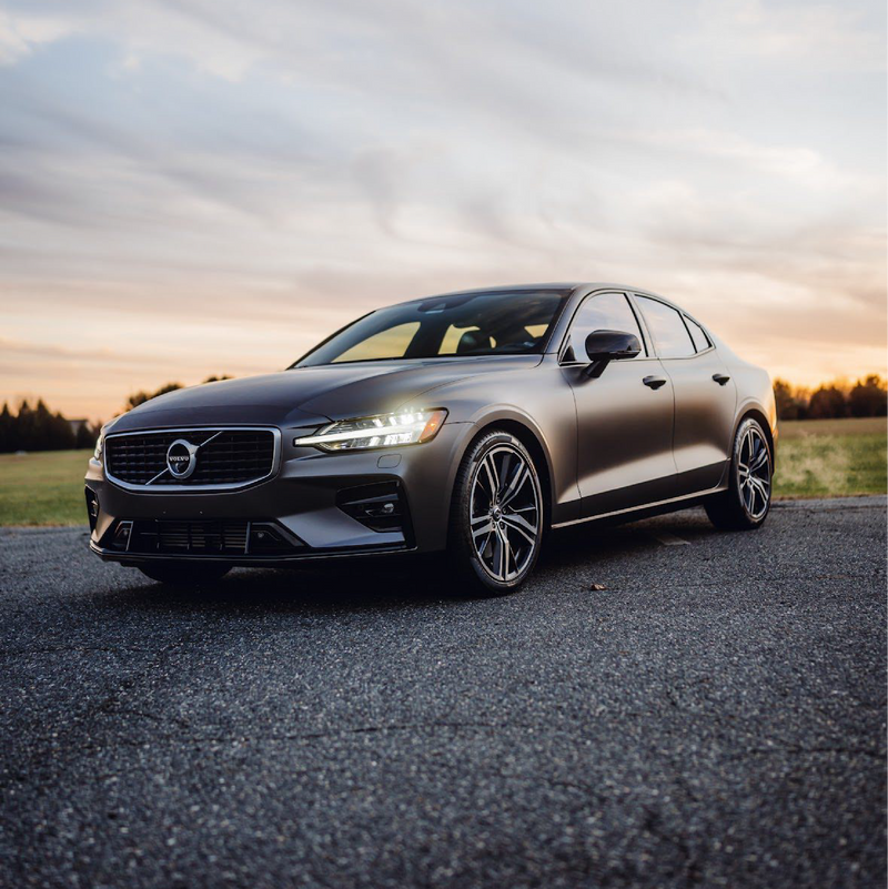 Volvo car parked on a road with a sunset in the background