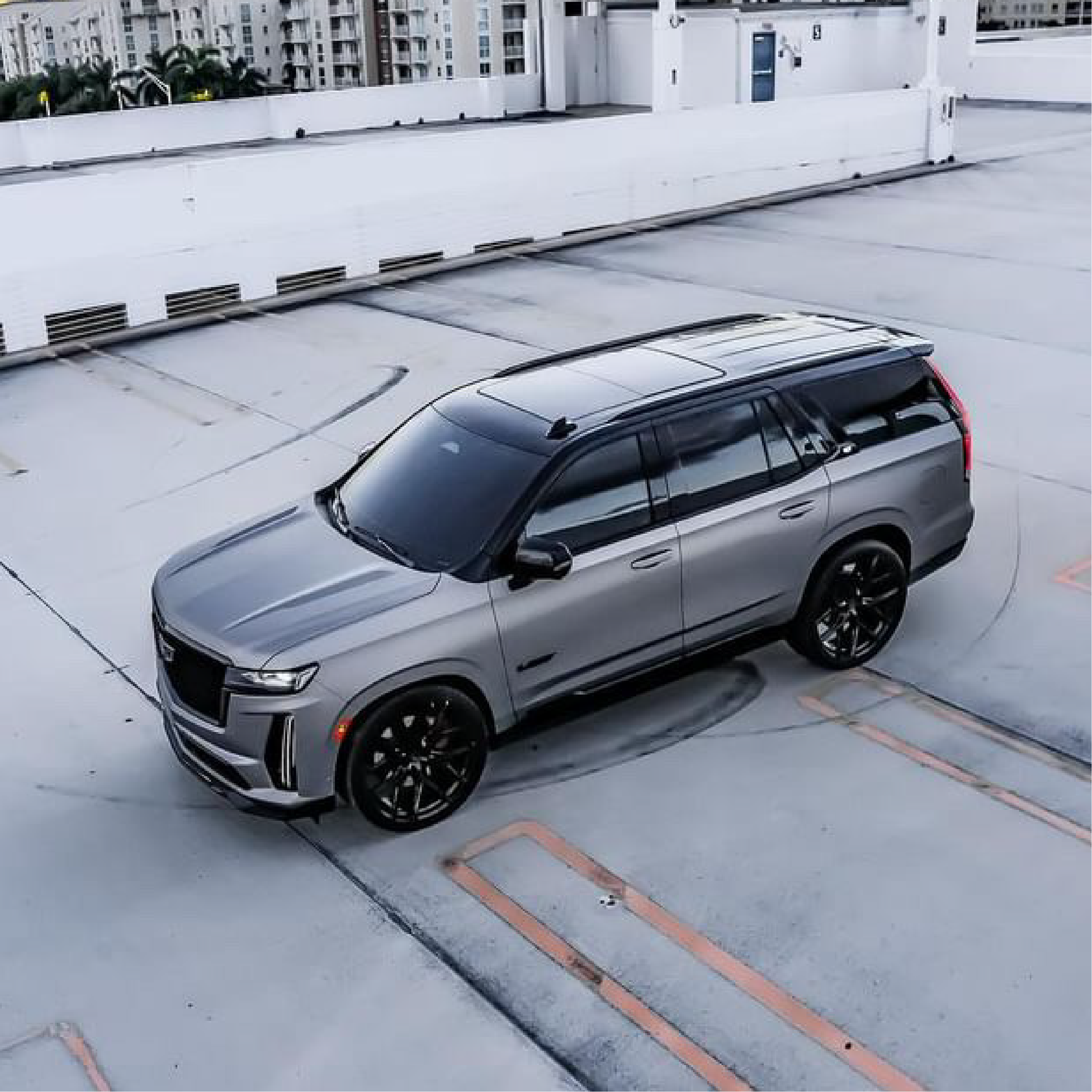 Gray SUV parked on a rooftop with buildings in the background