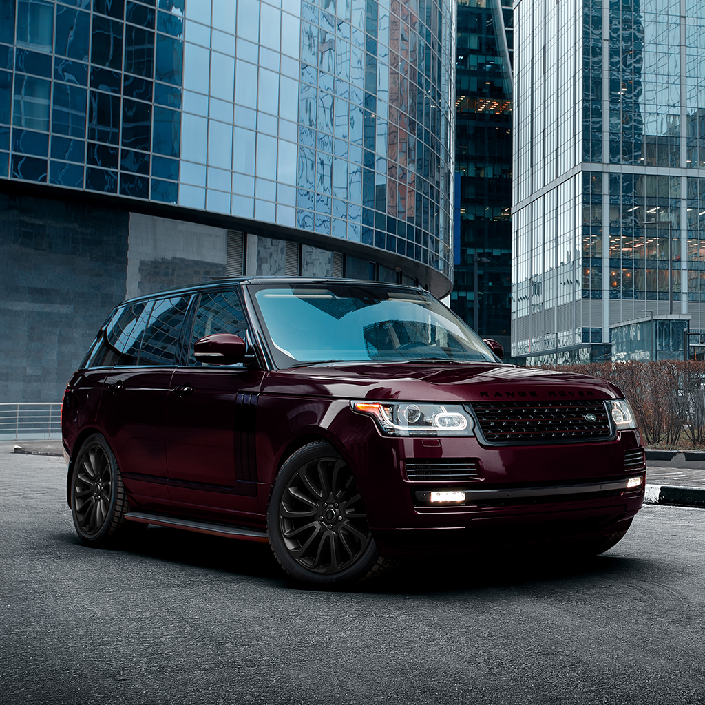 Maroon SUV parked in front of modern glass buildings