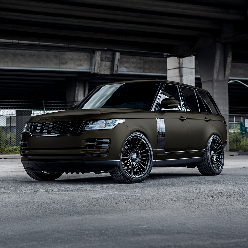 Black luxury SUV parked under a bridge